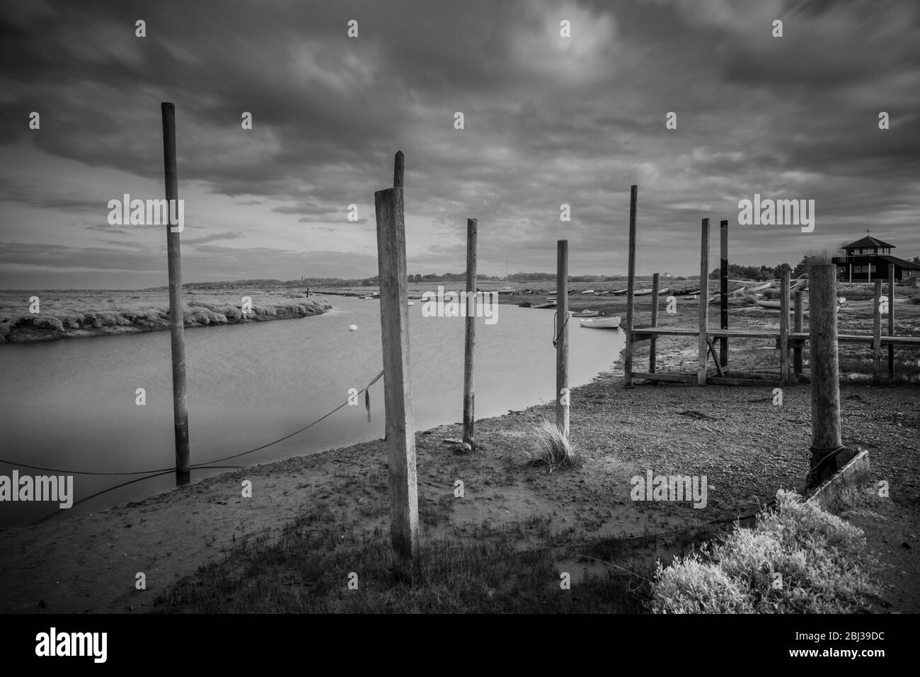 Molo e posti di ormeggio a Morston Quay, Norfolk, Inghilterra. Immagine a infrarossi in bianco e nero. Foto Stock