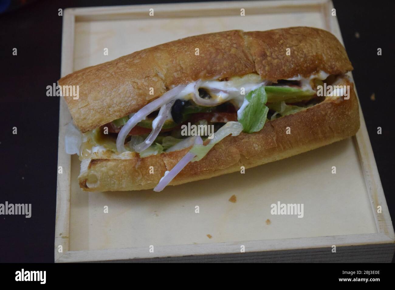 Hamburger con pane italiano e pezzi di pollo tandoori Foto Stock