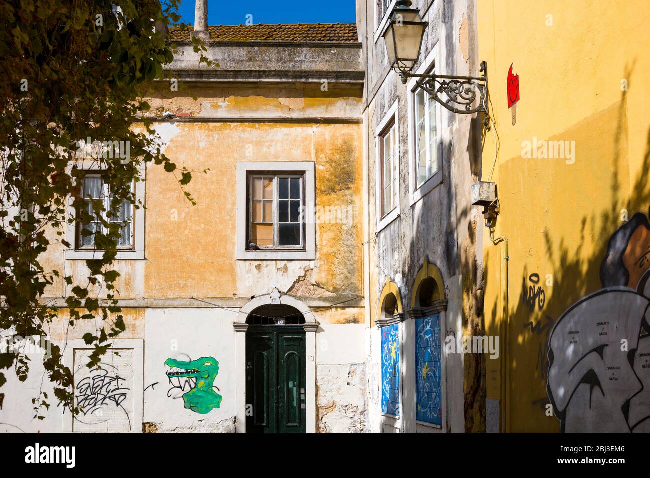 Graffiti e Street art su pareti dai colori vivaci di architettura tradizionale a Lisbona, Portogallo Foto Stock