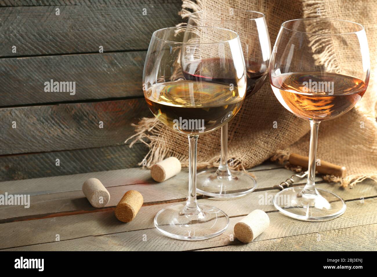 Composizione di bicchieri da vino e tappi su sfondo legno Foto Stock