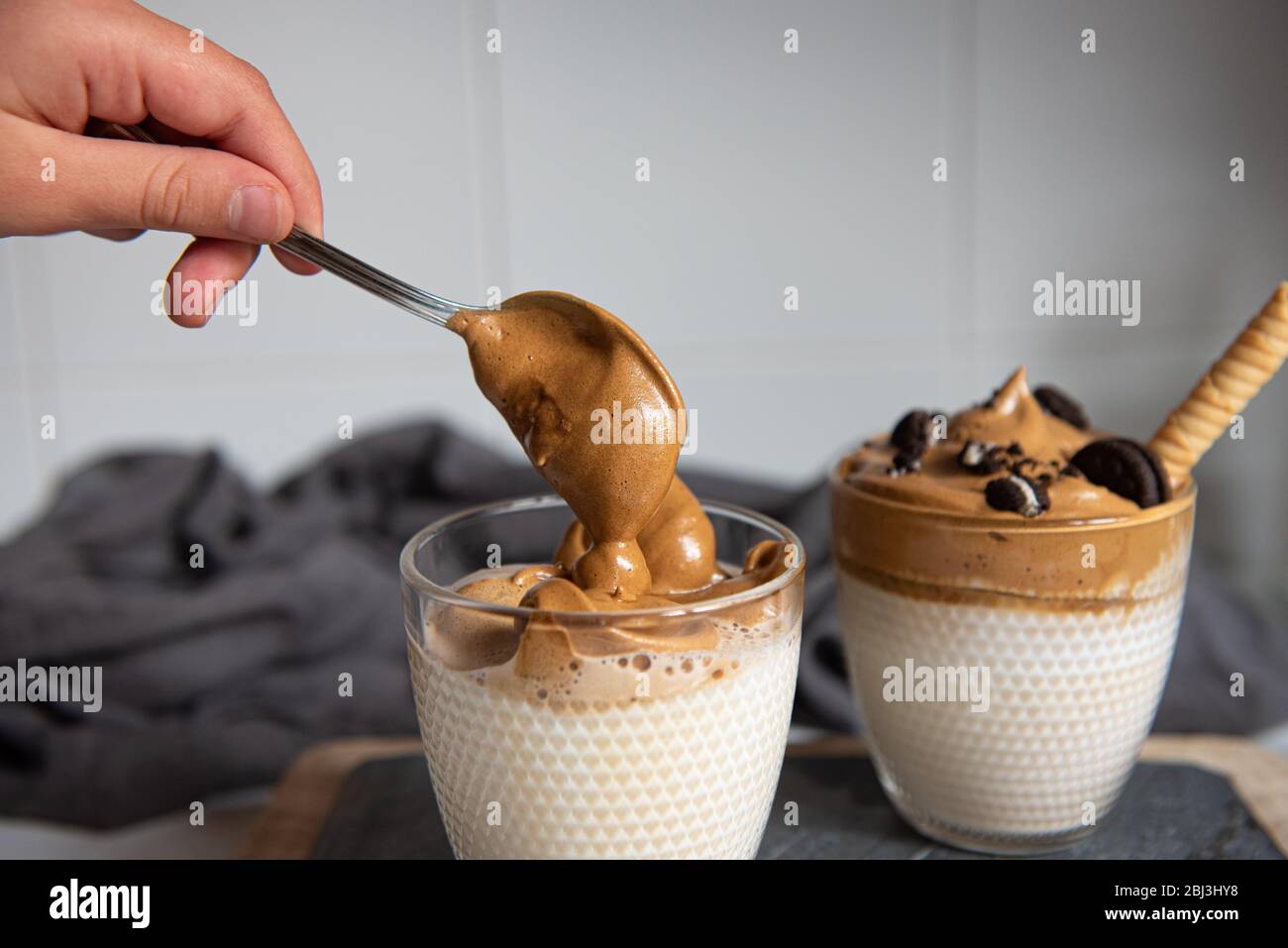 Dalgona caffè - caffè istantaneo o espresso in polvere montato con zucchero e acqua calda. Caffè freddo, montato, dalgona concetto. Foto Stock