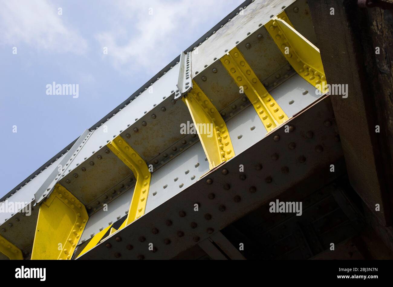 Angolo ascendente di travi e rivetti dipinti su un ponte ferroviario in metallo britannico a Sealter, Kent, Inghilterra Foto Stock