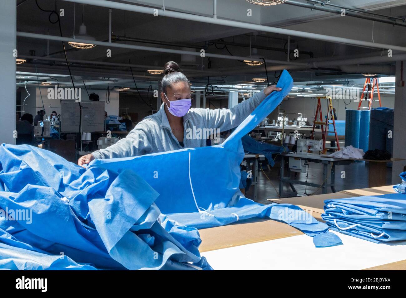 Detroit, Stati Uniti. 27 aprile 2020. Detroit, Michigan - i lavoratori dell'Industrial Sewing and Innovation Center fanno abiti isolati per gli operatori sanitari. ISAIC è una nuova apertura di produzione di beni cuciti e formazione senza scopo di lucro. Era destinata a produrre abbigliamento, ma spostata verso i camici di isolamento dovuto la pandemia del coronavirus. Credit: Jim West/Alamy Live News Foto Stock