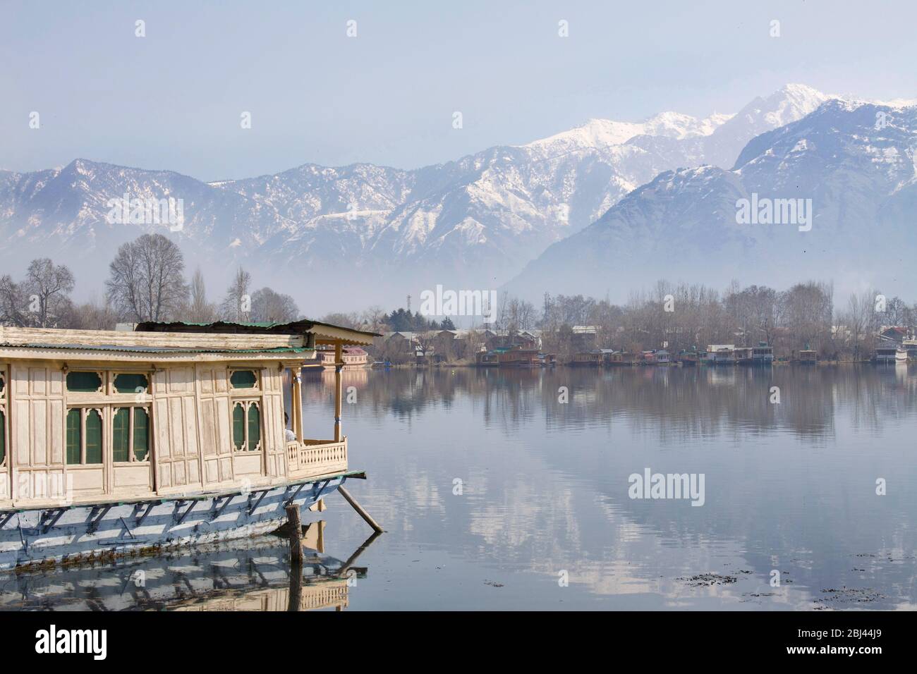 Casa galleggiante sul lago dal a Srinagar, capitale del Kashmir, guardando verso l'Himalaya. Foto Stock