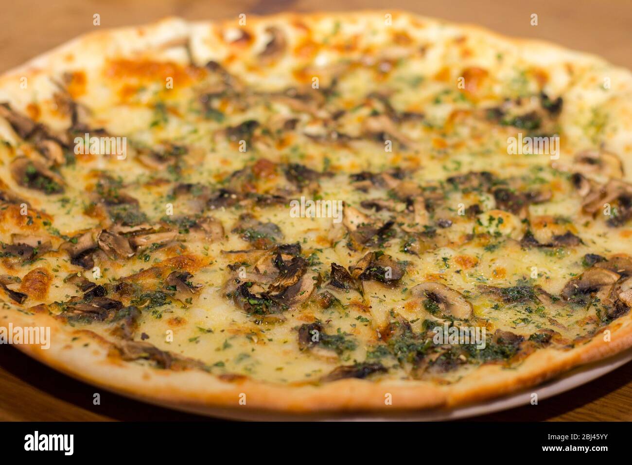 La pizza con funghi e formaggio viene cosparso di erbe italiane secche Foto Stock