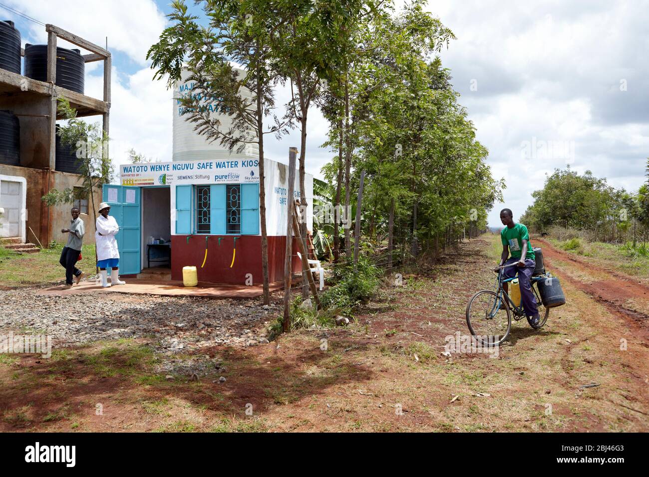 Il giovane uomo porta un barattolo pieno d'acqua dal pozzo di Mungetho, a nord di Naurobi alla sua bicicletta. Foto Stock
