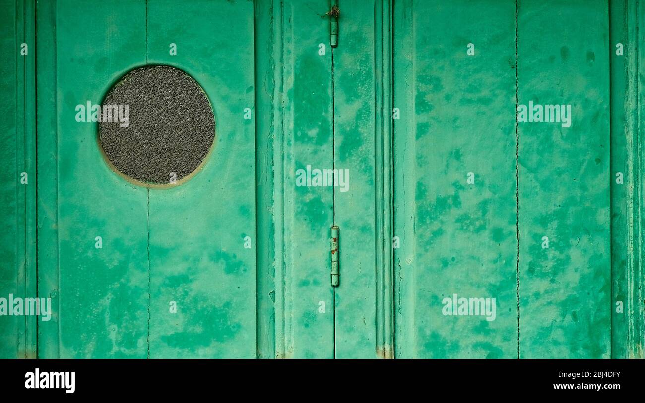 Porta verde con oblò rotondo. Foto Stock