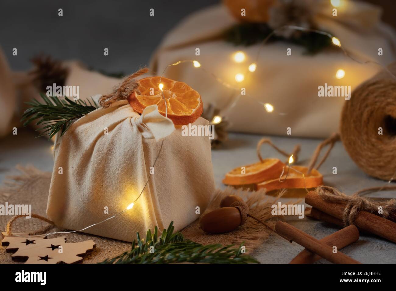 Zero spreco di natale concetto. Confezionato in tessuti naturali regali e decorazioni in materiali naturali con luci di natale. Foto Stock