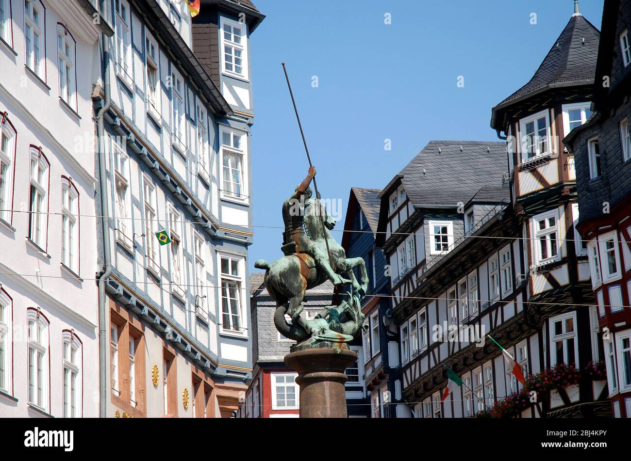 Piazza del mercato a Marburg, Germania, con monumento storico combattente drago preso dallo spazio pubblico Foto Stock