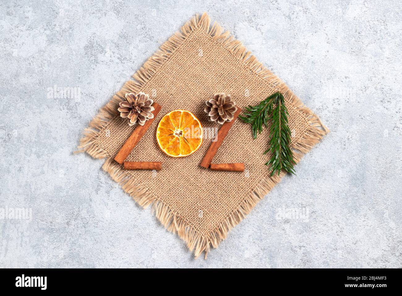 Festa di Natale con concetto zero rifiuti. Decorazione ecologica di Natale. Figure 2021 da materiali naturali su tela su tavola grigia. Foto Stock
