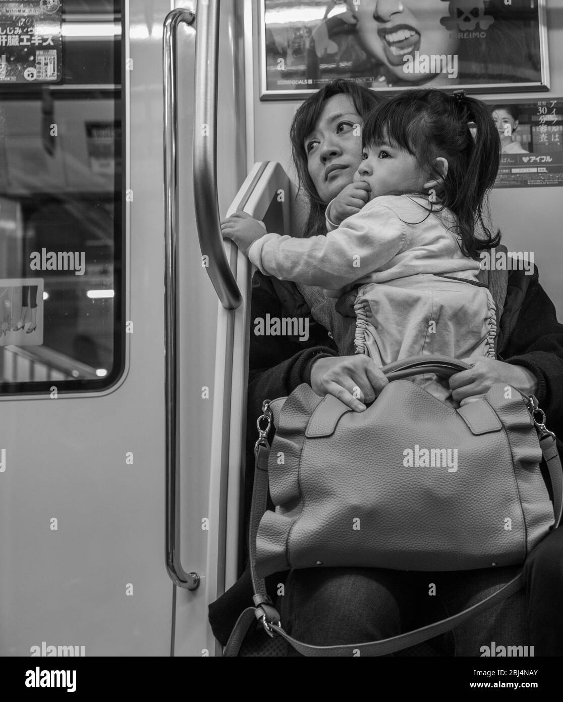Una madre e il suo giovane bimbo tornano a casa in treno, Tokyo Japan. Foto Stock