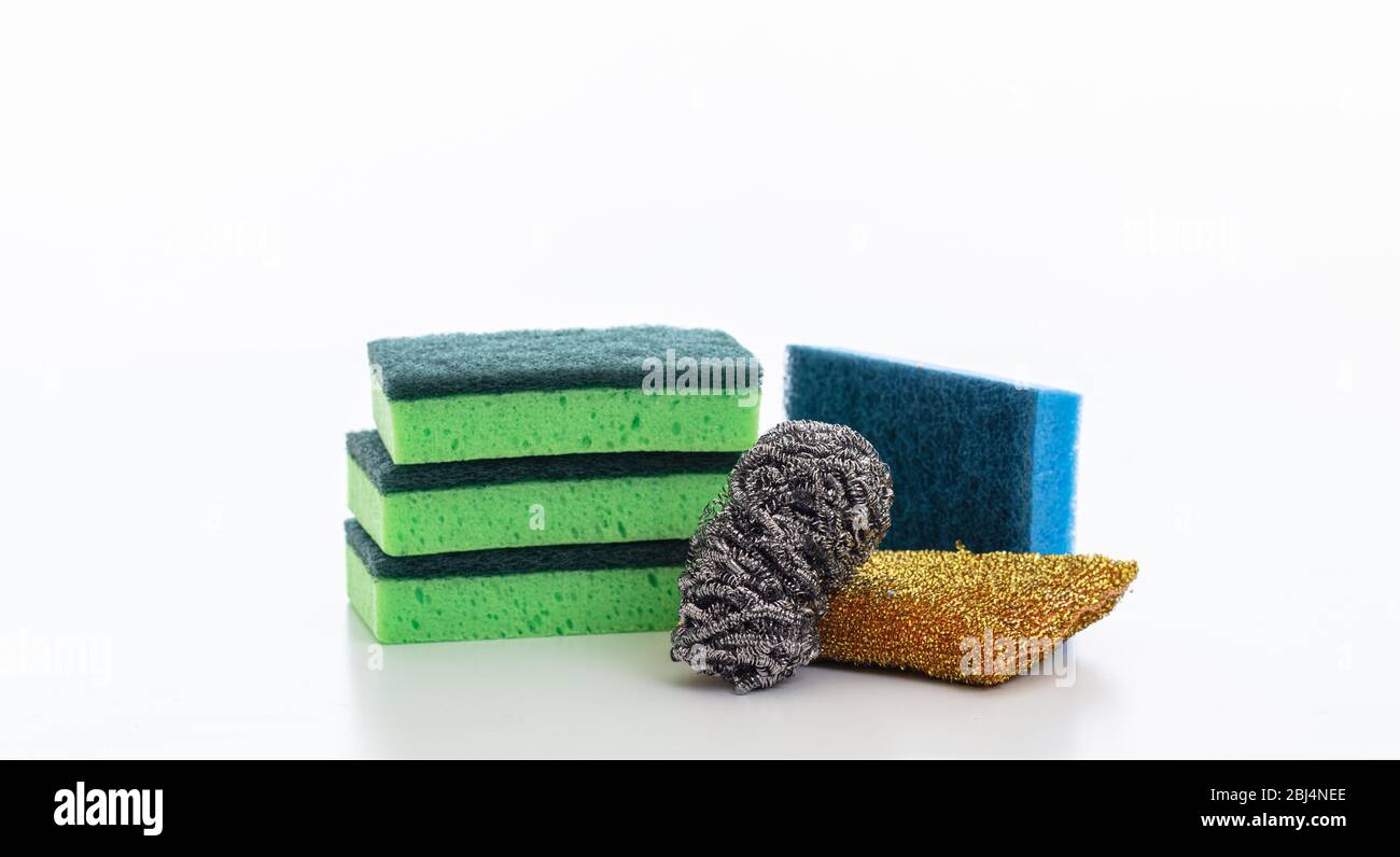 Varietà di spugne detergenti isolate su fondo bianco. Spugne varie per lavaggio stoviglie, forniture per uso domestico Foto Stock