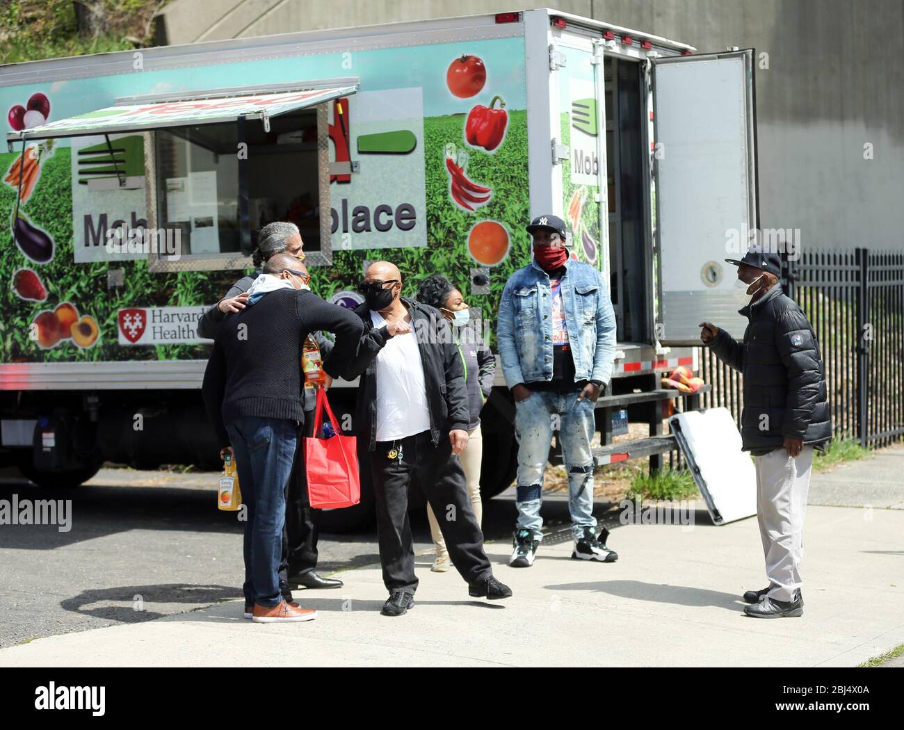 Bridgeport, CT, Stati Uniti. 28 Aprile 2020. Il cibo viene distribuito a Bridgeport, Connecticut attraverso Hang Time, un'organizzazione di base che sostiene i recentemente incarcerati, con cibo, amicizia, aiuto per ottenere un lavoro e altri servizi di supporto. Il cibo è offerto con l'aiuto del Centro per l'equità alimentare e lo sviluppo economico del Consiglio delle Chiese del Grande Bridgeport, e della Harvard Pilgrim Healthcare Foundation. Credit: Stan Godlewski/ZUMA Wire/Alamy Live News Foto Stock