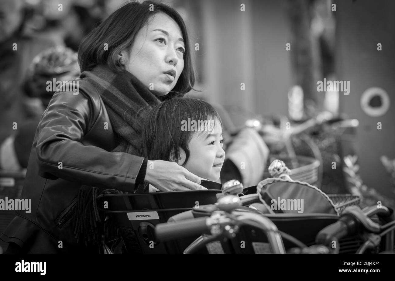 Una madre giapponese aiuta sua figlia fuori delle biciclette prima che vadano a fare shopping al mercato di Ameyoko a pochi metri di distanza Foto Stock