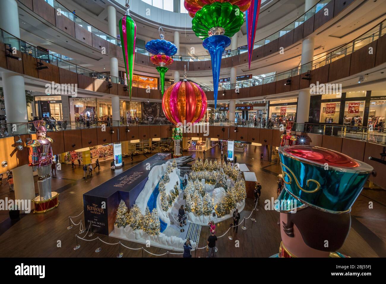 I soldati giganti del nutcracker si levano all'attenzione e si affacciano su un villaggio di Natale nel Dubai Mall. Foto Stock