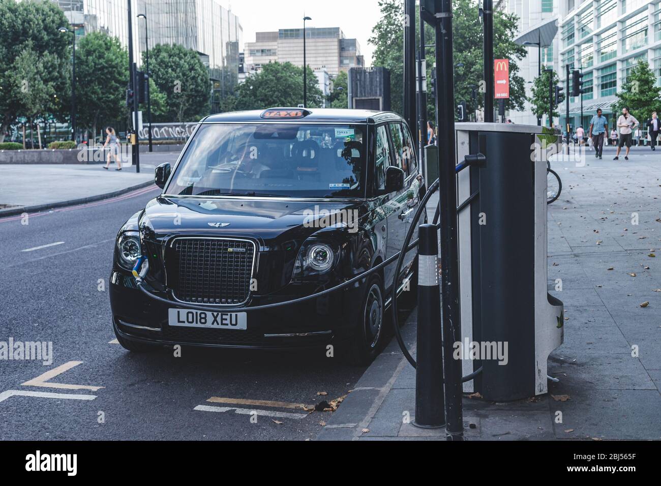 Londra/UK-26/07/18: Carrello elettrico Hackney alla stazione di carica con il cavo di alimentazione collegato. La prima cabina completamente elettrica, la Dynamo, era la Foto Stock