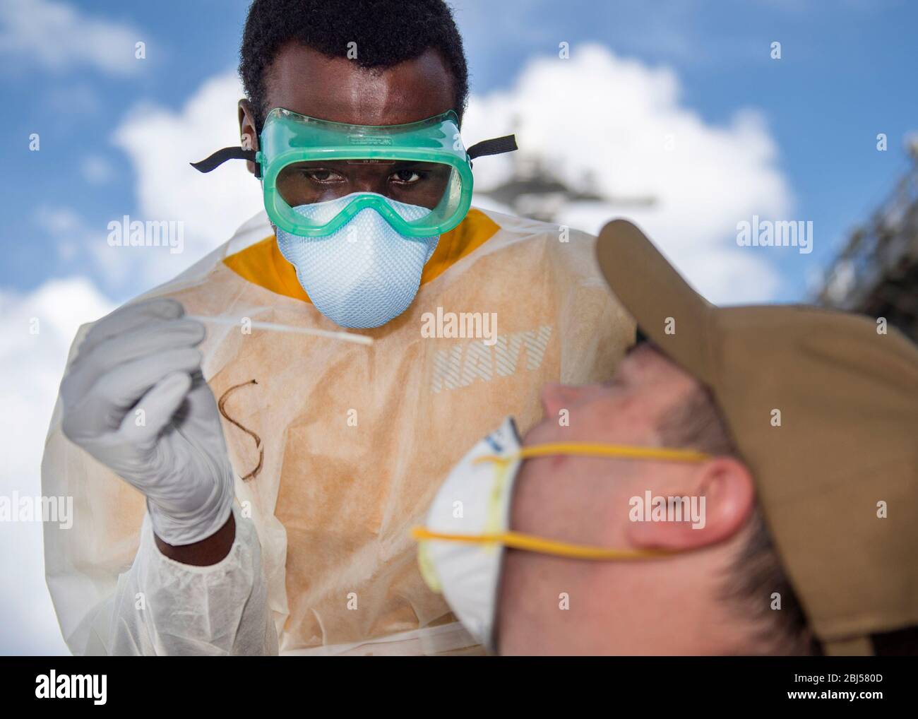 U.S. Navy Hospitalman Christian Akins, prende un campione di sangue da un marinaio assegnato alla portaerei USS Theodore Roosevelt come parte del tracciamento dei contatti per COVID-19, esplosione di coronavirus a bordo della nave 22 aprile 2020 ad Ava, Guam. Foto Stock