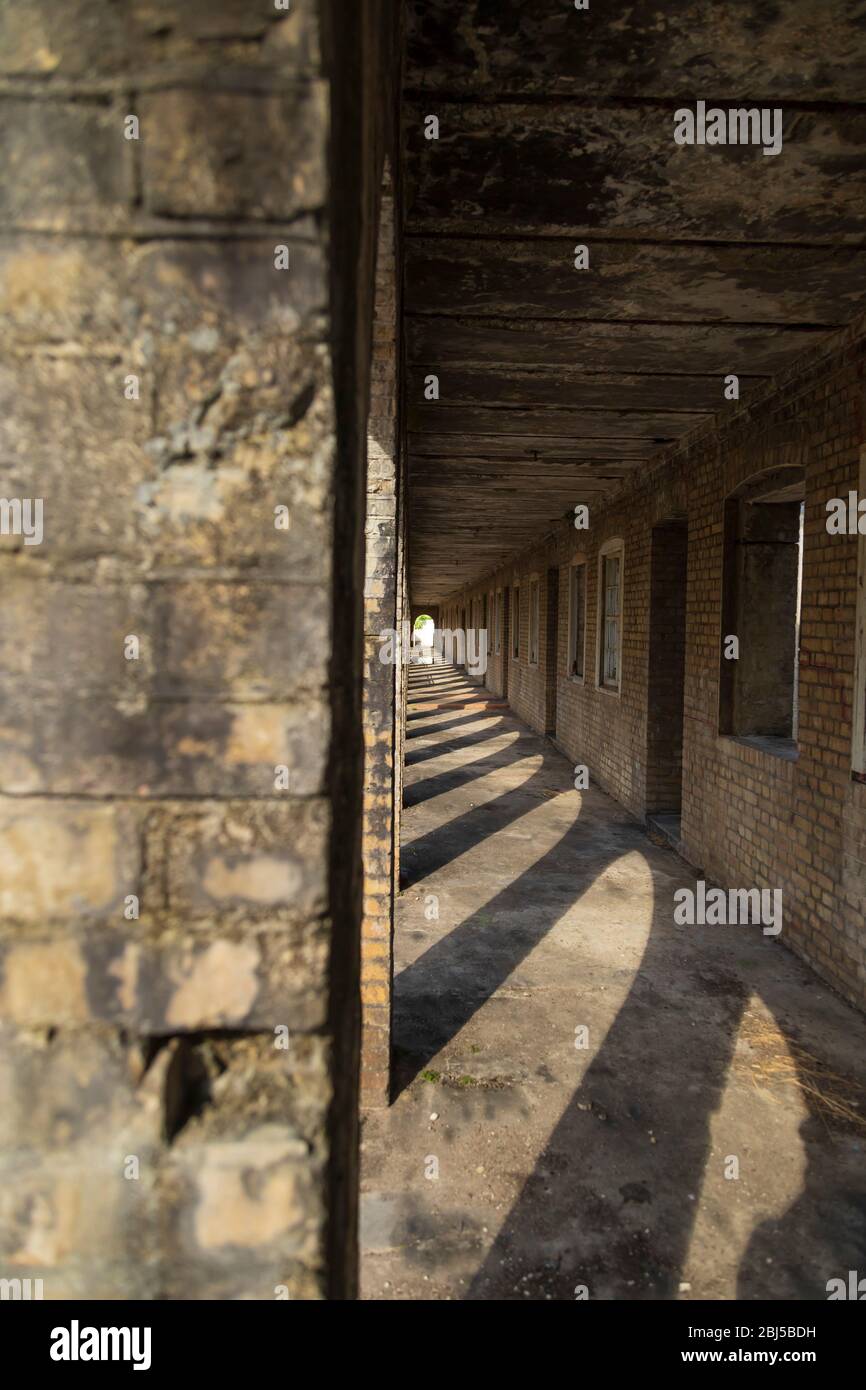 punto di fuga visto da un'estremità di un corridoio di un vecchio edificio coloniale con gli ingressi alle camere sulla destra Foto Stock