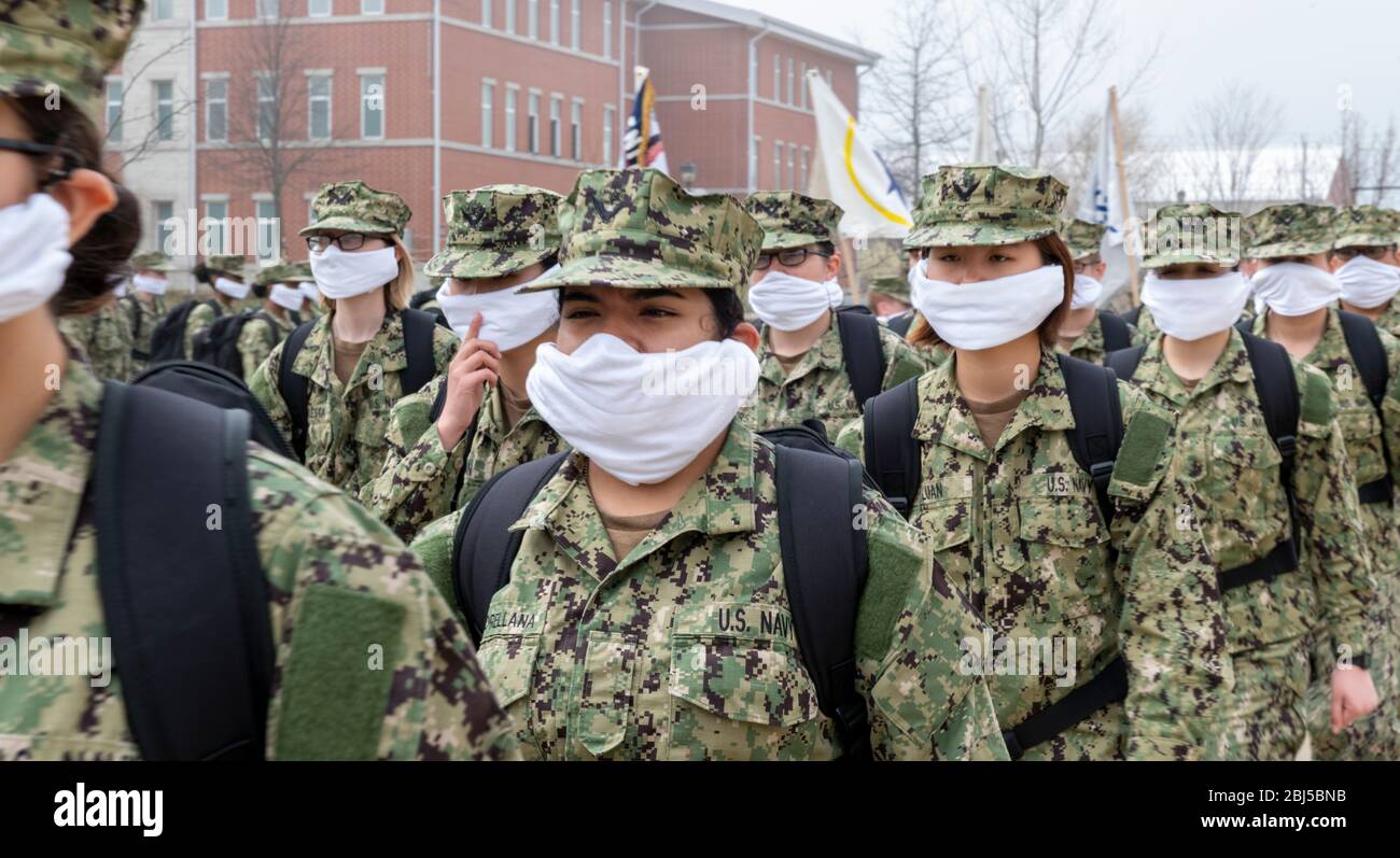 La Marina degli Stati Uniti recluta maschere di faccia di usura per impedire la diffusione di COVID-19, coronavirus come loro marciano in formazione al comando di addestramento di reclutamento 15 aprile 2020 a Great Lakes, Illinois. Foto Stock