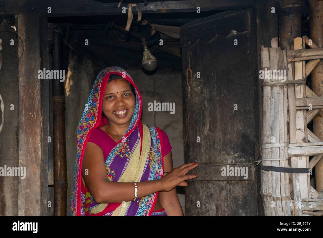 felice donna rurale in piedi alla porta Foto Stock