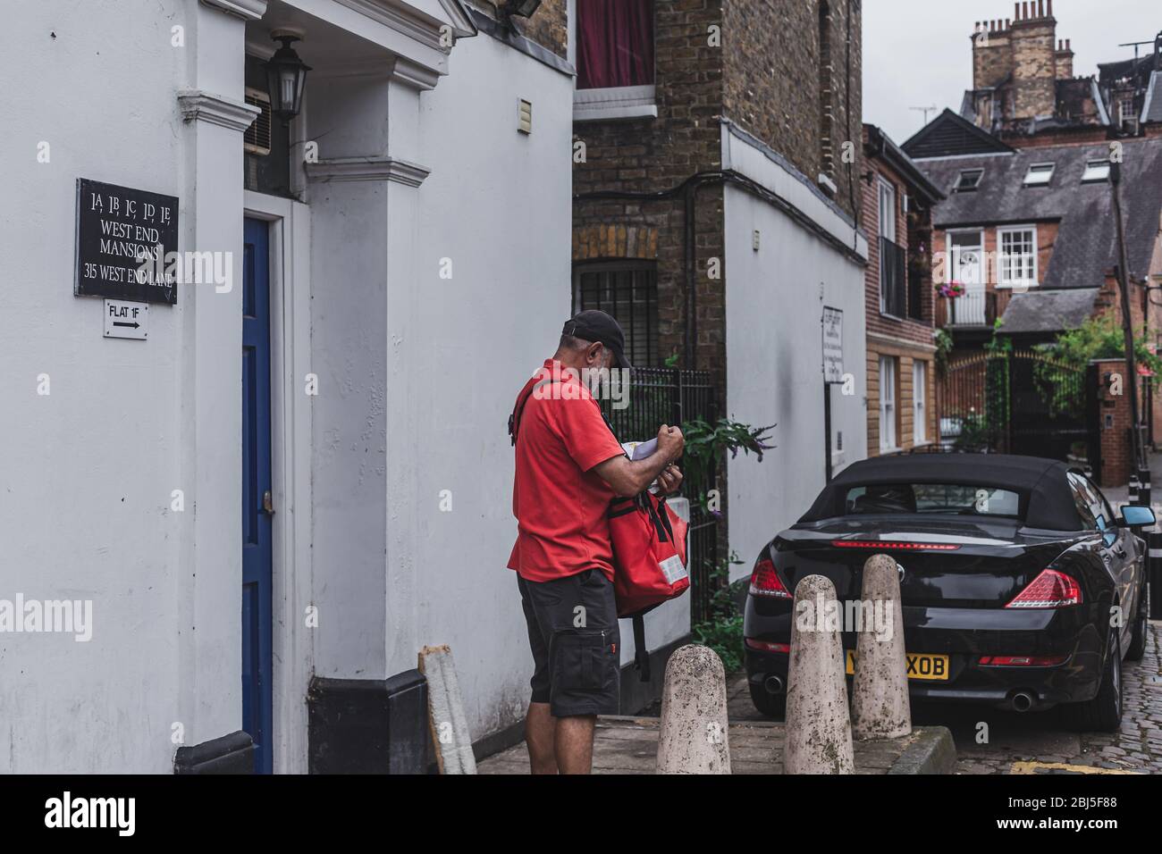 London/UK-30/7/18: Il postino di Royal Mail che consegna la posta. Una borsa a mano per corrispondenza è un tipo di borsa postale che un portadoccia per lettere utilizza per l'assistina Foto Stock