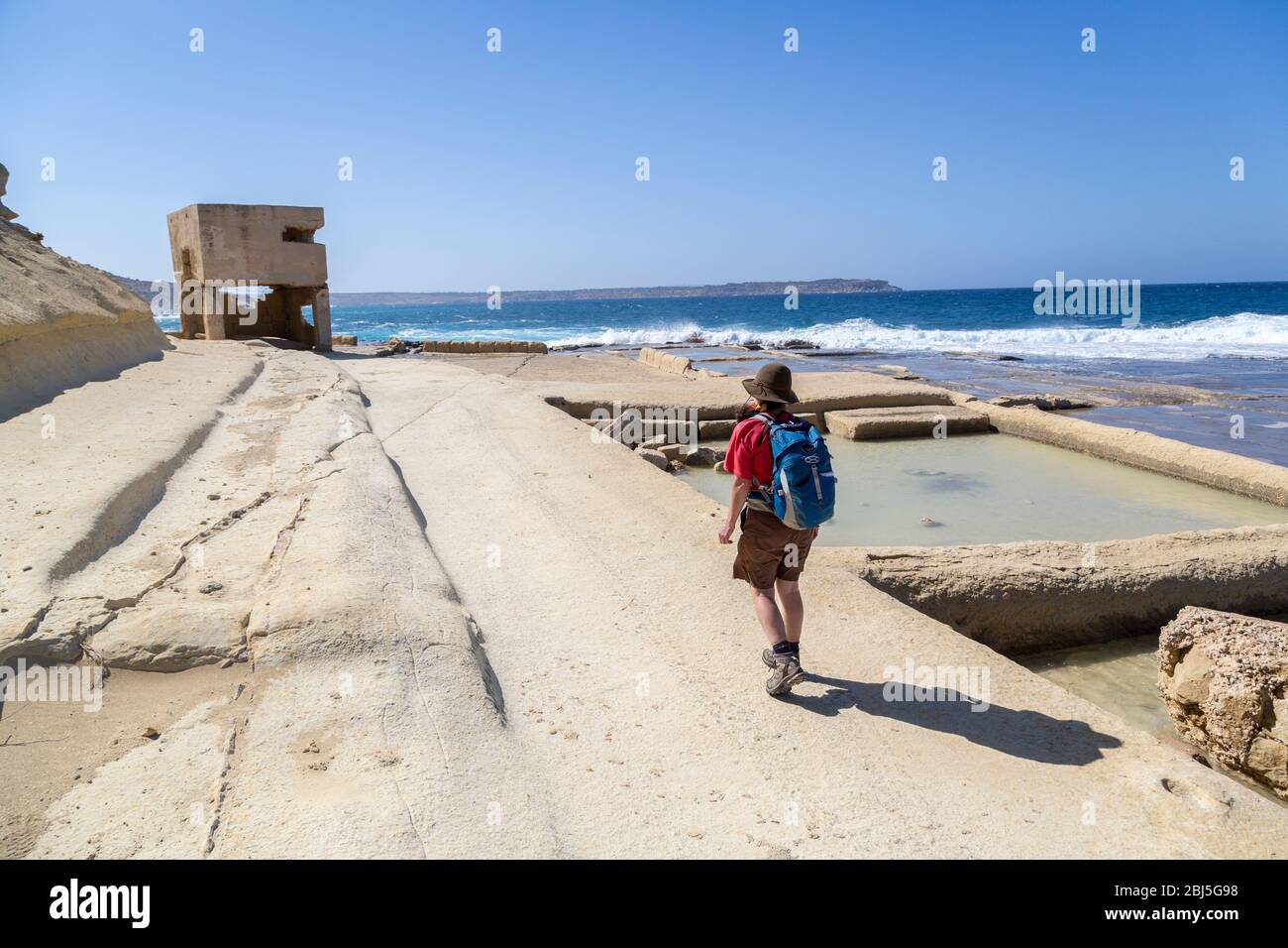Resti di postazioni di armi della seconda Guerra Mondiale sulla costa a tal Blata, con antiche saline, Malta Foto Stock