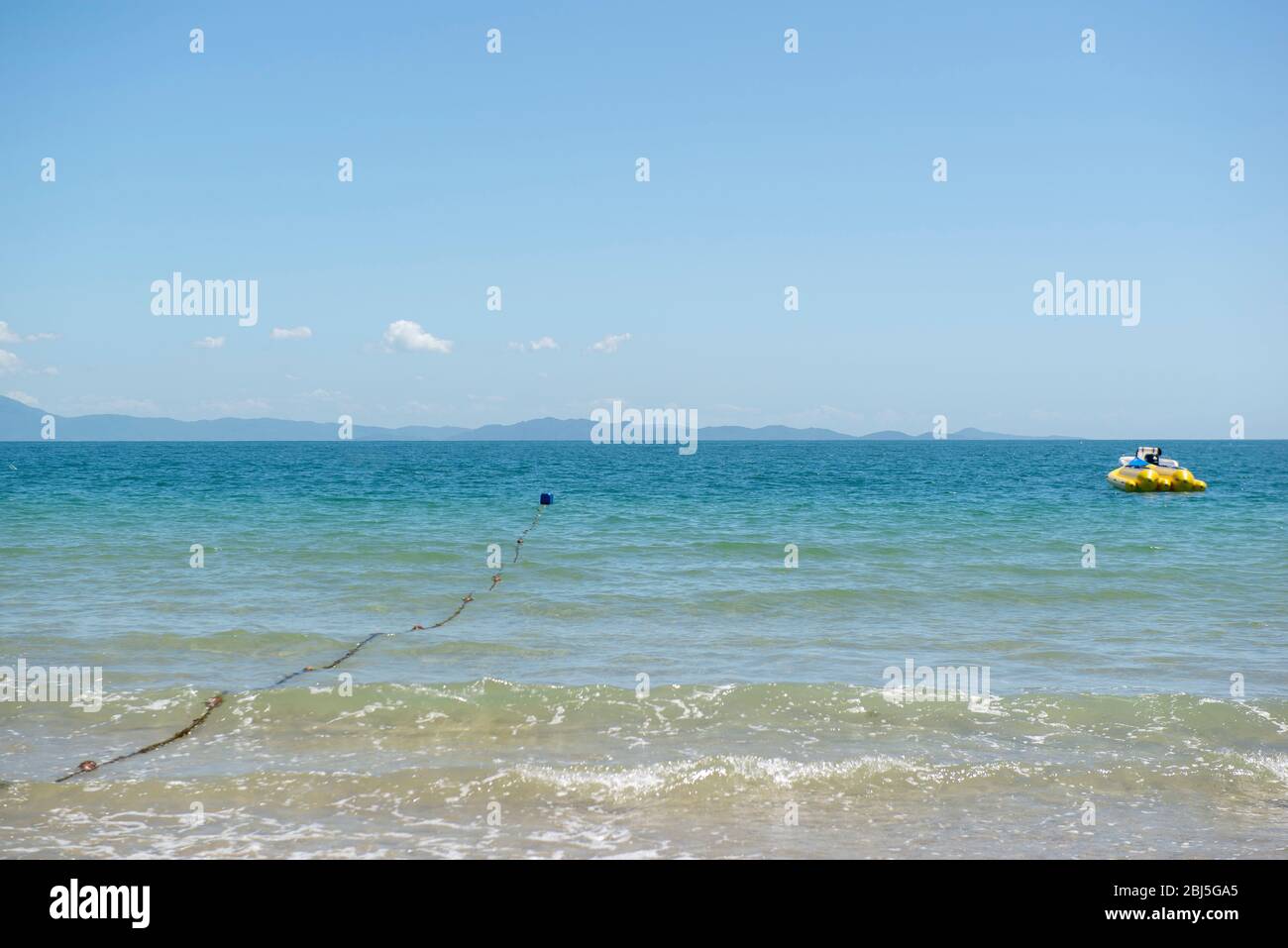 Bella spiaggia nel Brasile meridionale - Città di Florianopolis. Bella vista sul mare verdastro. Giorno di sole nuvoloso - cielo limpido in estate. Bana gialla Foto Stock