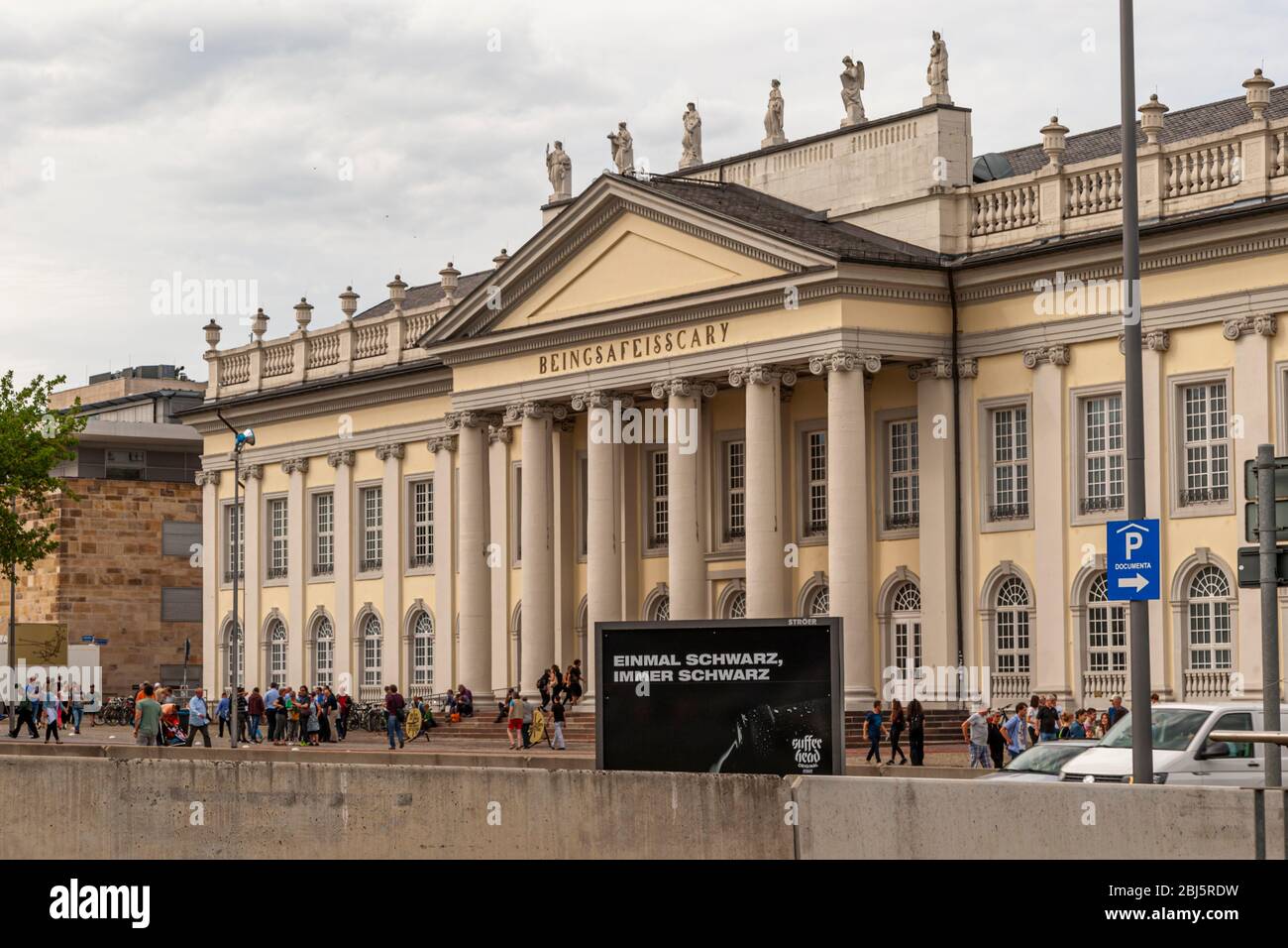"Essere al sicuro è spaventoso" sostituisce la solita scritta "Museo Fridericianum" sul frontone del Fridericianum a Kassel, in Germania – un'opera dell'artista turca Banu Cennetoğlu per la documenta 14. I visitatori si radunano la sera presto davanti al colonnato neoclassico. Foto Stock