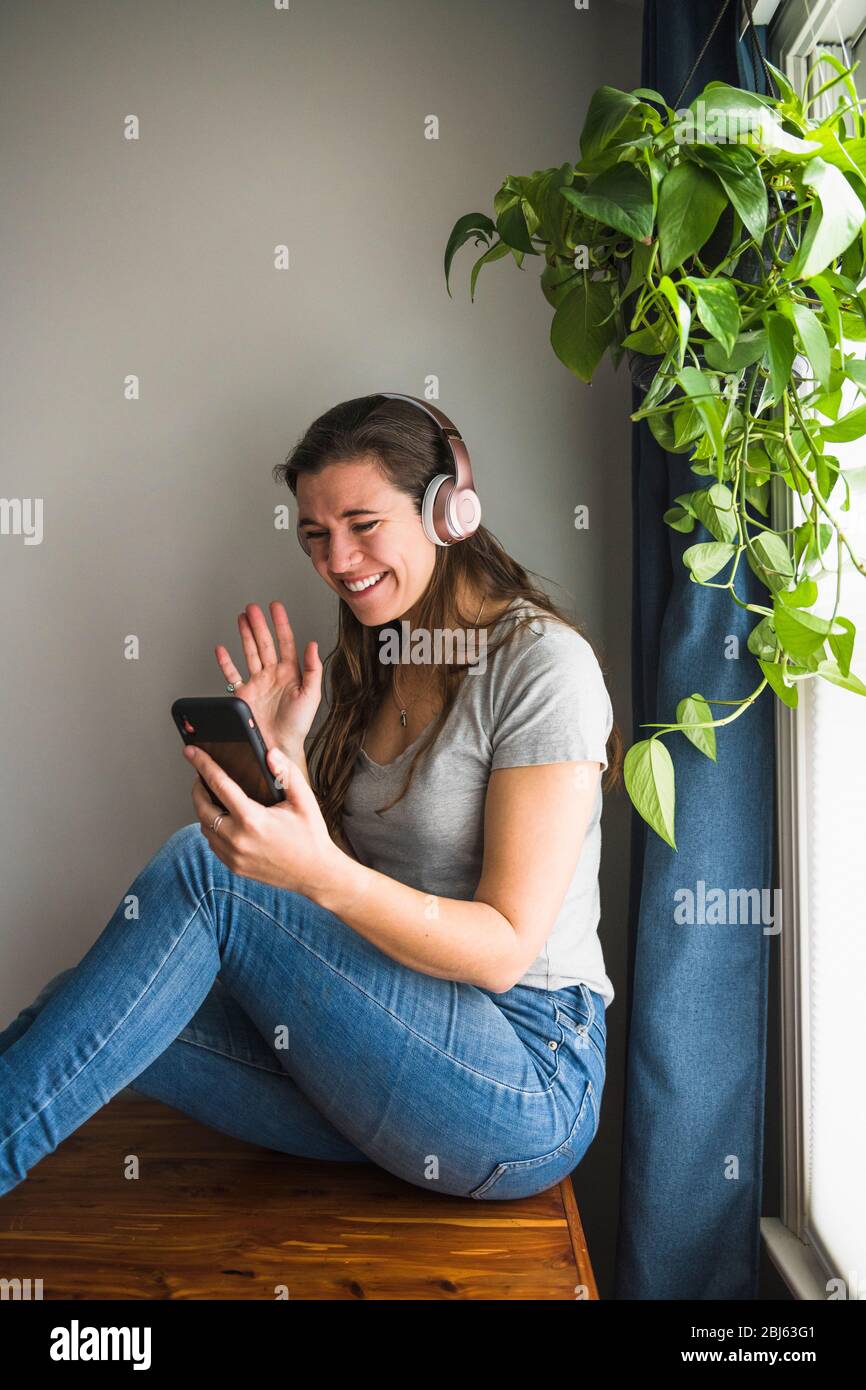 Ritratto sorridente di Donna individuale Facetiming da casa Foto Stock