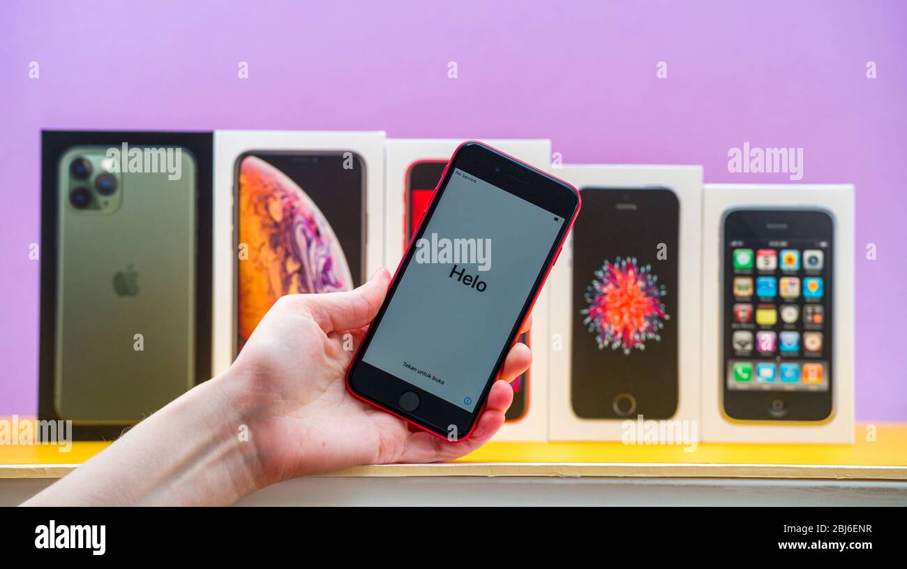 Parigi, Francia - 26 aprile 2020: Donna mano che tiene ultimo iPhone se 2020 telefono con più pacchetti schede di Apple computer iPhone smartphpone iPhone 3gs, se 2016, XS e 11 Pro Foto Stock
