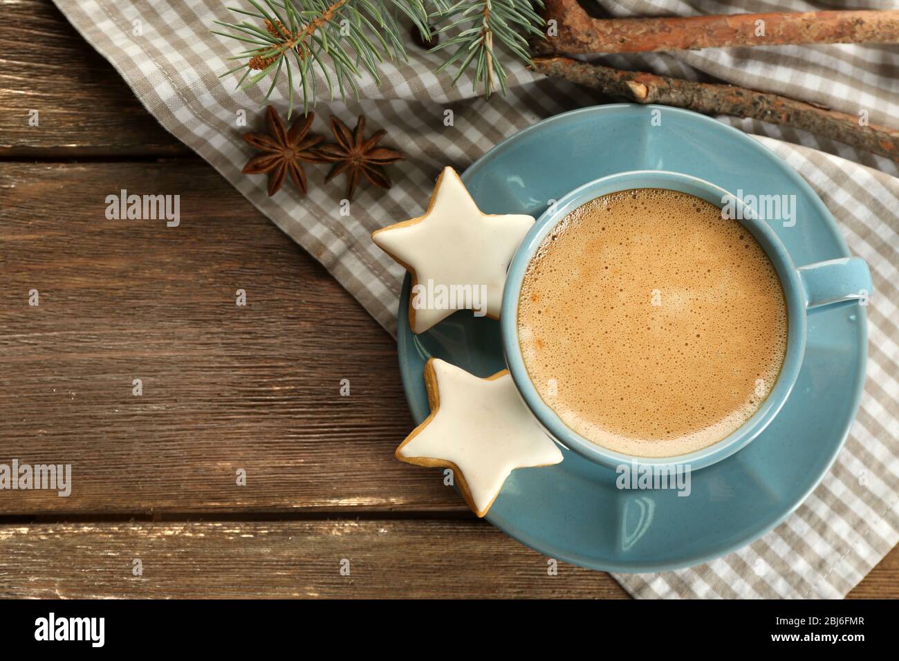Tazza di caffè con biscotti a forma di stella e rametto di albero di Natale su tovagliolo Foto Stock