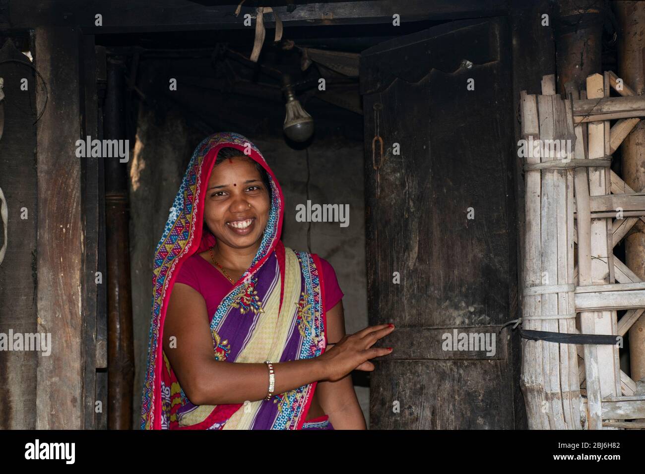 Donna rurale che sta alla porta di casa in India Foto Stock