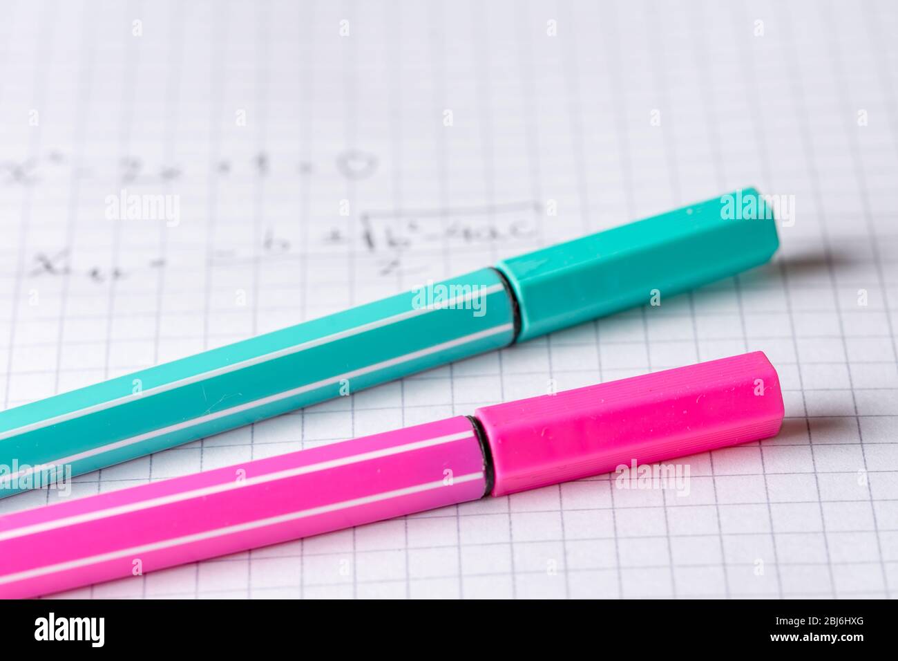 due evidenziatori su carta grafica scolastica con equazione matematica Foto Stock
