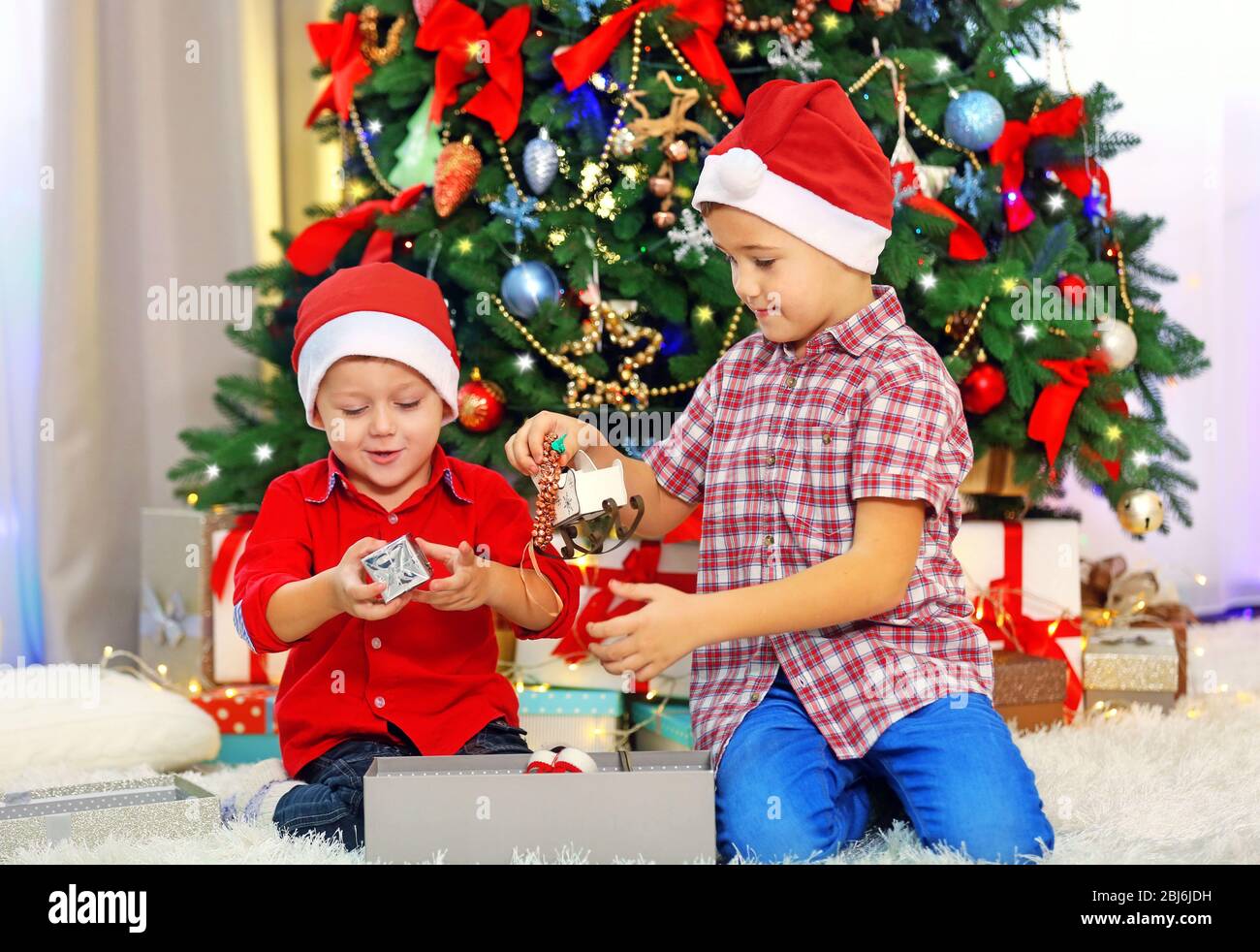 Regali Carini Di Natale.Due Carini Fratelli Piccoli Regali Di Apertura Su Sfondo Decorazione Di Natale Foto Stock Alamy