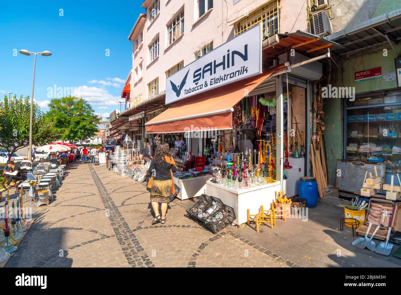Una donna cammina davanti a un colorato negozio di tubi di gancino e altri souvenir e regali vicino al mercato e bazar Eminonu di Istanbul, Turchia. Foto Stock