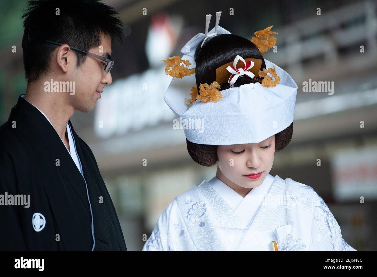Sposa e sposo scattando foto di matrimonio al Santuario Meiji di Tokyo, Giappone. Saranno poi condotti da sacerdoti e fanciulle alla cerimonia vera e propria Foto Stock