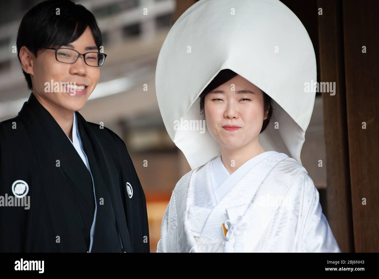 Sposa e sposo scattando foto di matrimonio al Santuario Meiji di Tokyo, Giappone. Saranno poi condotti da sacerdoti e fanciulle alla cerimonia vera e propria Foto Stock