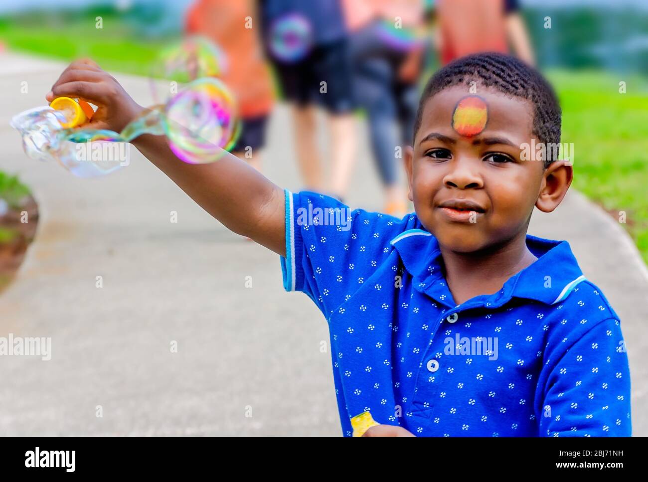 Un ragazzo soffia bolle a Langan Park, 13 aprile 2019, a Mobile, Alabama. Il parco di 720 acri offre una vasta gamma di opportunità ricreative. Foto Stock