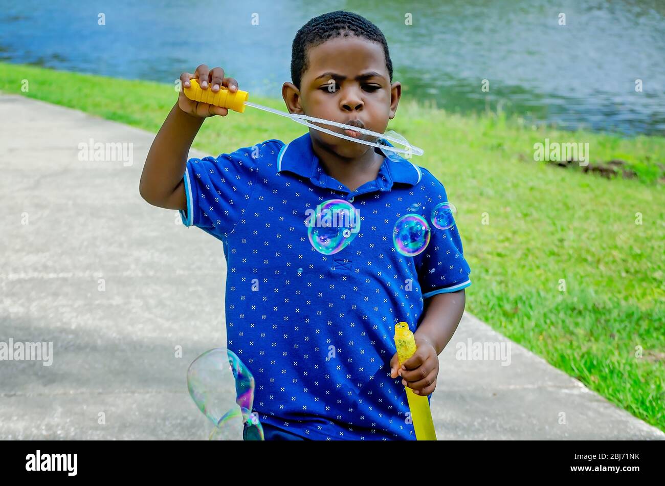 Un ragazzo soffia bolle a Langan Park, 13 aprile 2019, a Mobile, Alabama. Il parco di 720 acri offre una vasta gamma di opportunità ricreative. Foto Stock