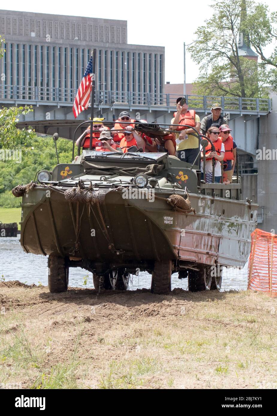 Un veicolo militare anfibio chiamato anche anatra, esce dall'acqua con un carico di persone in giubbotti salvagente Foto Stock