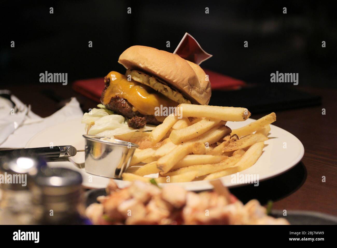 Hamburger classico con patatine fritte e bandiera in cima. Foto Stock