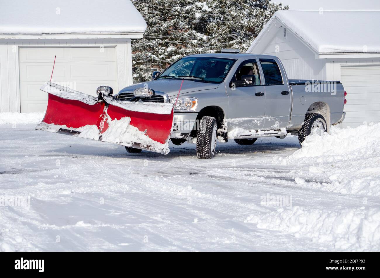 l'aratro da neve su un camion argentato sta muovendo la neve durante la giornata invernale Foto Stock