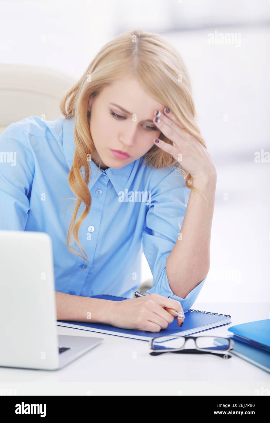 Donna stanca al notebook in ufficio Foto Stock