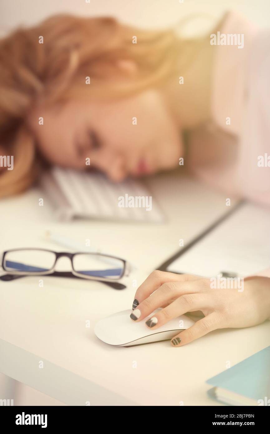 Stanco della donna al computer in ufficio Foto Stock