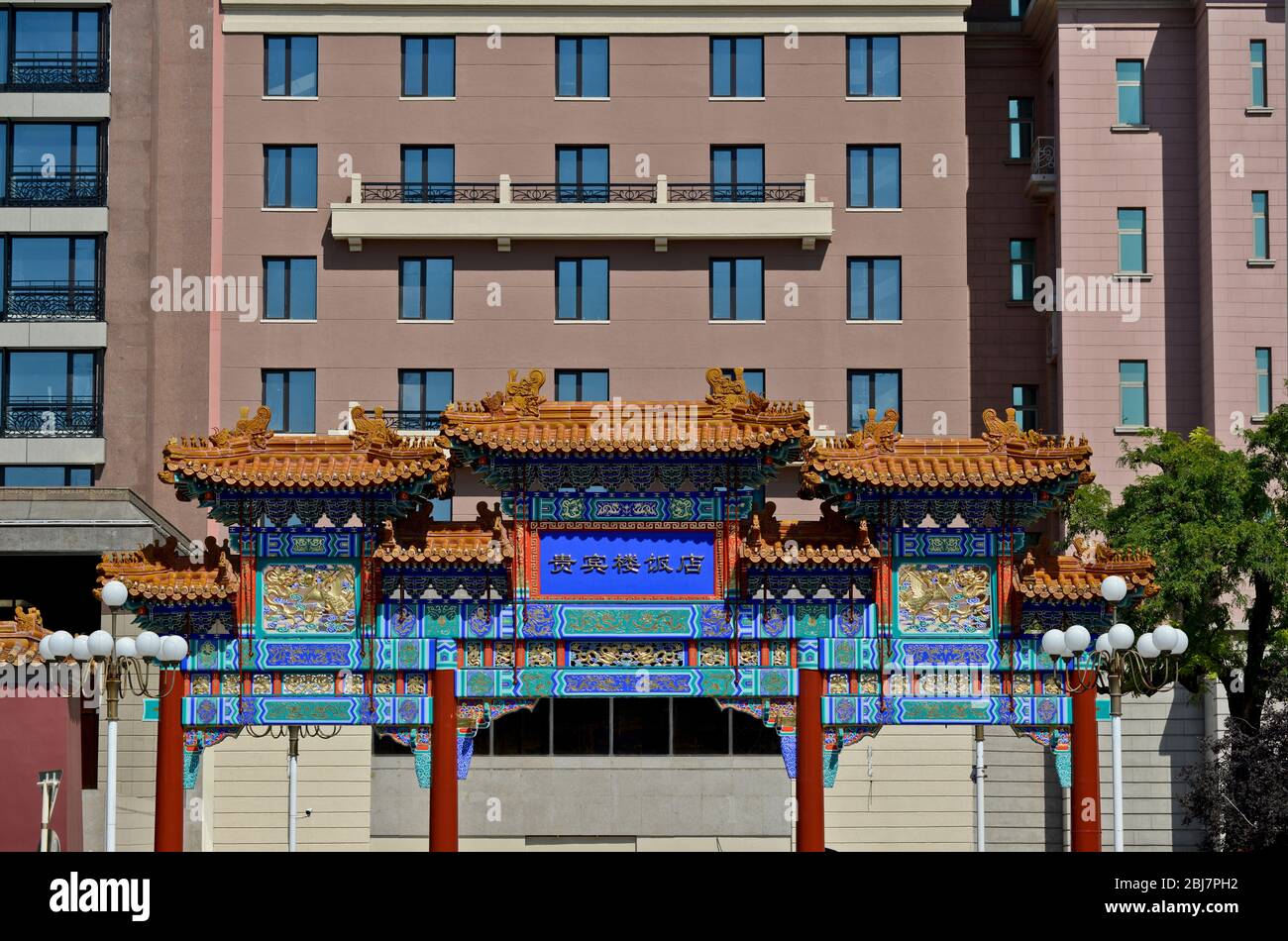 Tradizionale arco cinese di fronte ad un edificio moderno. Qianmen East Street, Pechino. Cina Foto Stock