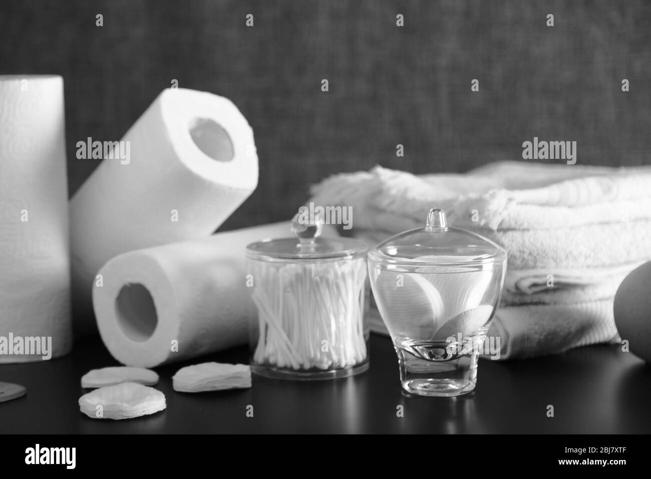 Set da bagno con asciugamani, spugne e bastoncini auricolari su sfondo grigio Foto Stock