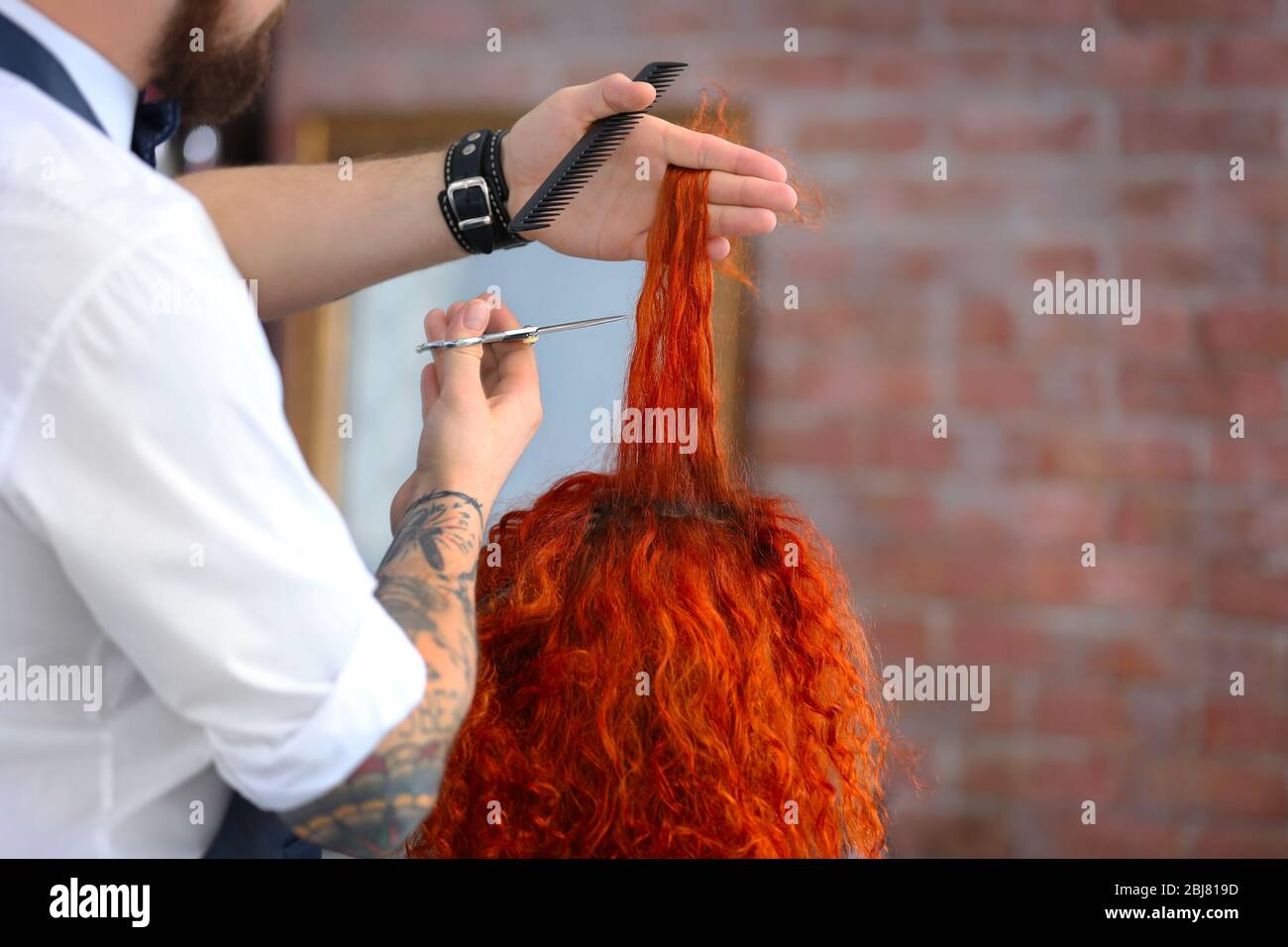 Parrucchiere taglio ricci rossi Foto Stock