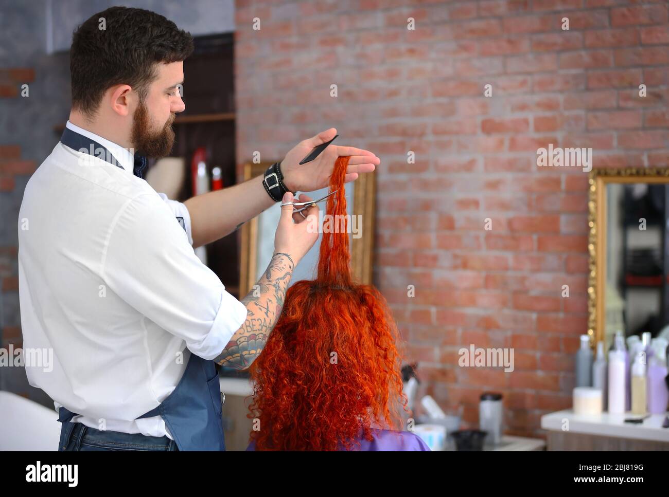Parrucchiere taglio ricci rossi Foto Stock
