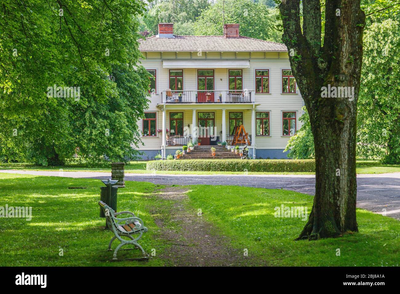 Idilliaca casa di legno bianco in un parco pubblico in estate Foto Stock