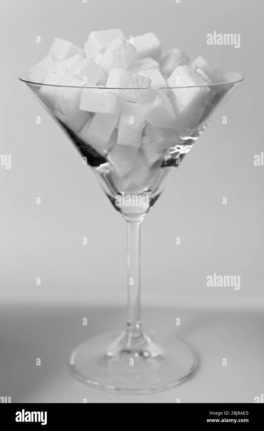 Bicchiere Martini ripieno di zucchero a velo su fondo grigio Foto Stock